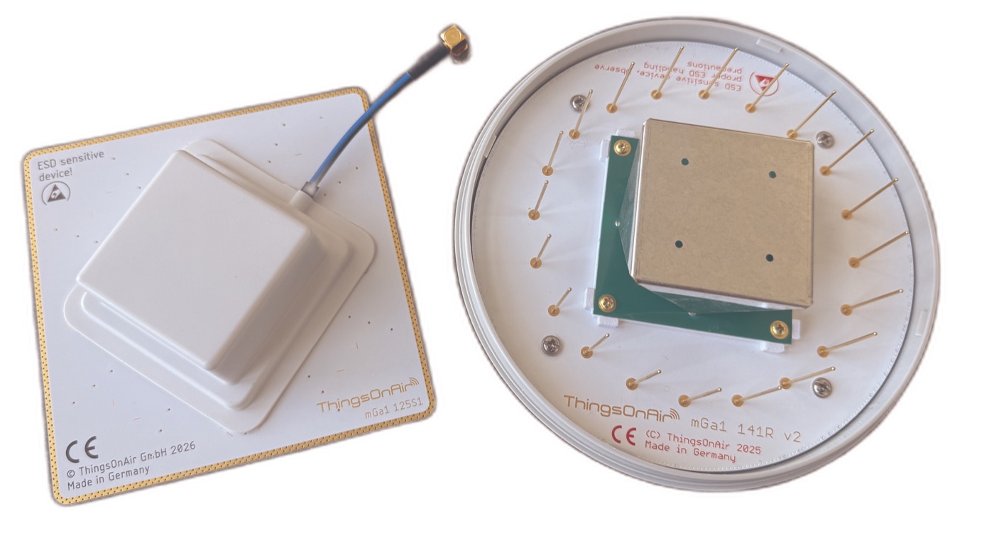 Two mGa1 antennas: on the left on a square ground plane under the white protective cap, on the right opened, on a round ground plane with resonator ring